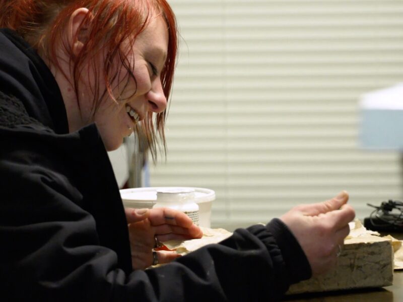 A woman sitting at a table is smiling