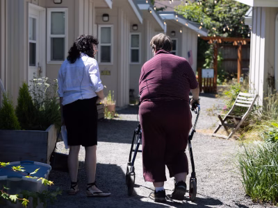 A member of Multnomah County's new Homeless Mobile Intake Team, funded with dollars collected through the Supportive Housing Services tax, meets with a client at the Homeless Services Department's St. Johns Village alternative shelter.