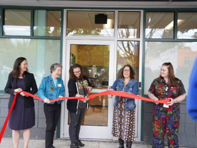 People cut the ribbon in front of the North Portland Drop-In Center