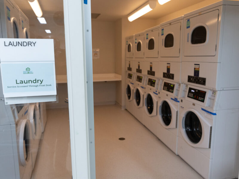A room with multiple washers and dryers.