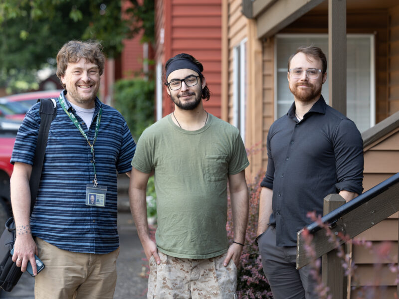 Jayson stands with two other people.