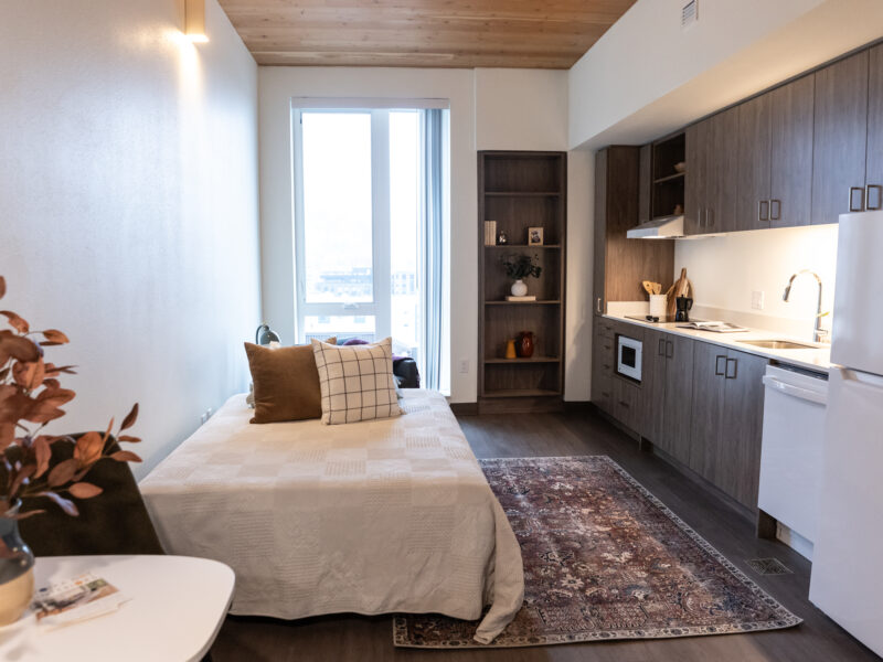 Small apartment with kitchen and bed.